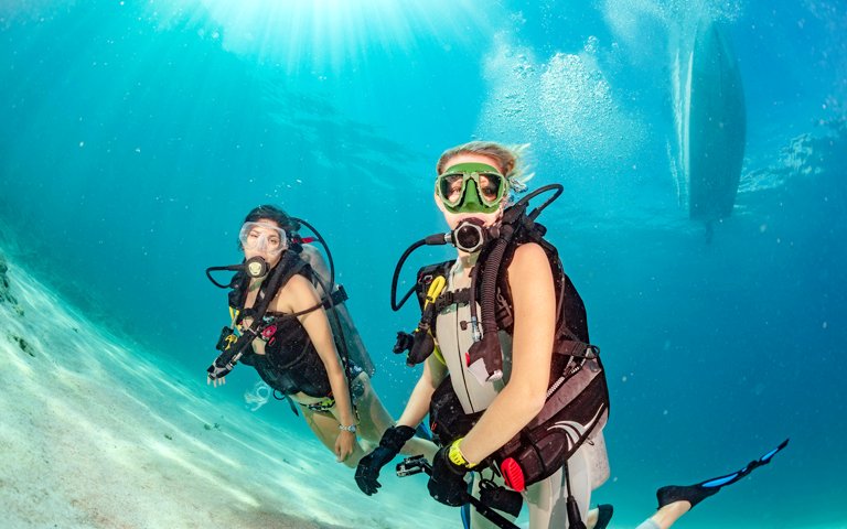 beautiful girls looking at you while swimming underwater