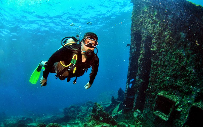 man-doing-scuba-diving-near-shipwreck