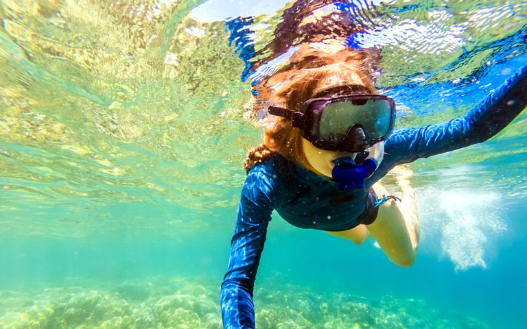 Young women at snorkeling in the tropical water